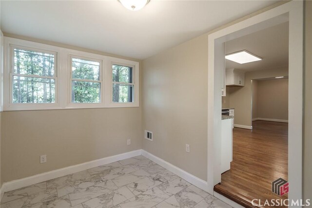 218 E Vine St, Monroe, GA 30655 - empty room featuring marble finish floor, visible vents, and baseboards