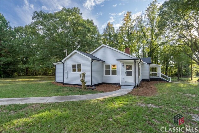 218 E Vine St, Monroe, GA 30655 - view of front of house featuring a chimney and a front lawn