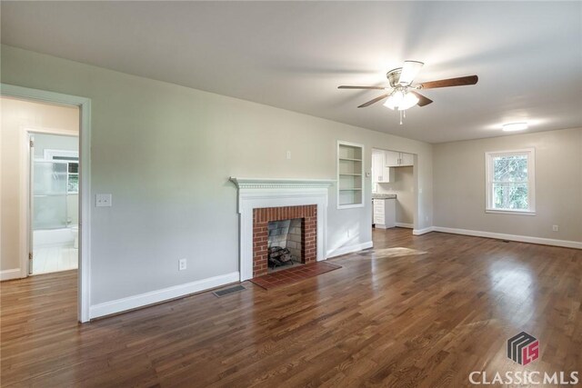 218 E Vine St, Monroe, GA 30655 - unfurnished living room with ceiling fan, baseboards, a brick fireplace, and dark wood-style flooring