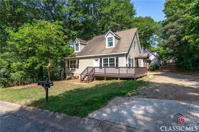 new england style home with a front yard and a deck