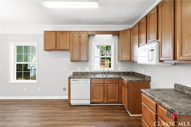 kitchen with dark hardwood / wood-style flooring, sink, white appliances, and crown molding