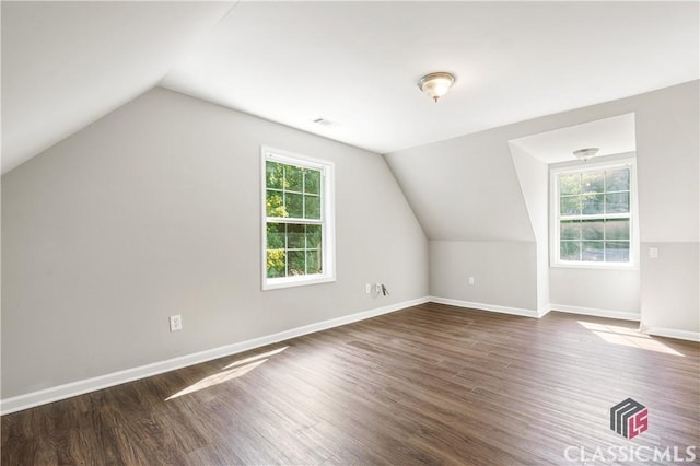 bonus room with a healthy amount of sunlight, dark hardwood / wood-style floors, and vaulted ceiling