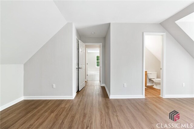 additional living space featuring hardwood / wood-style flooring and vaulted ceiling