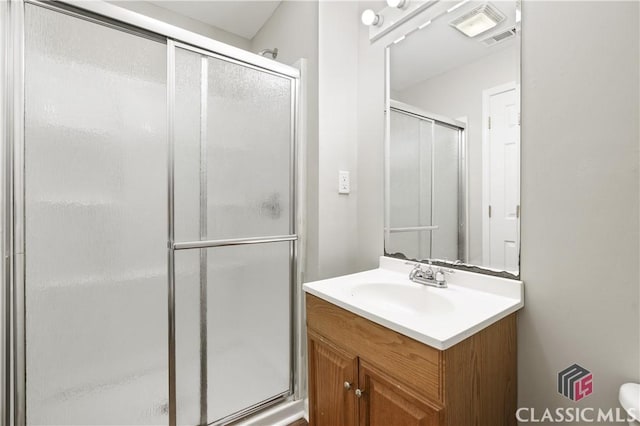 bathroom featuring vanity and a shower with door