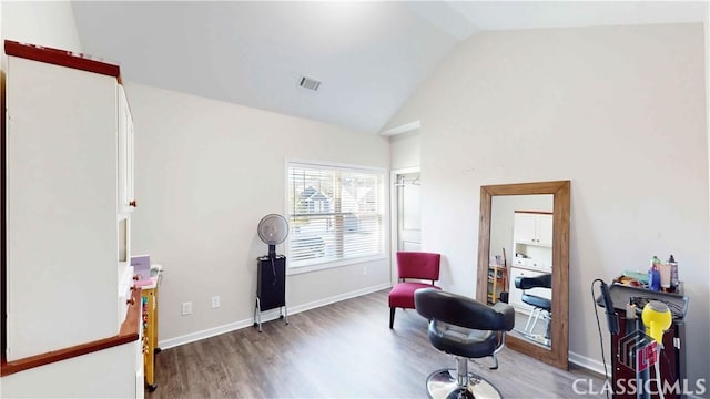 sitting room featuring visible vents, baseboards, wood finished floors, and high vaulted ceiling