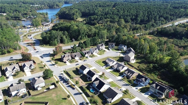 aerial view featuring a forest view, a water view, and a residential view
