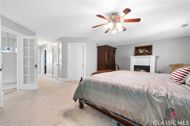 carpeted bedroom with ceiling fan and a textured ceiling