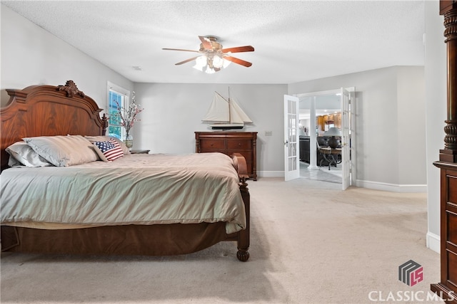 bedroom with a textured ceiling, light colored carpet, french doors, and ceiling fan