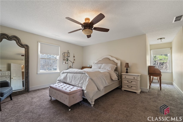 carpeted bedroom featuring a textured ceiling and ceiling fan