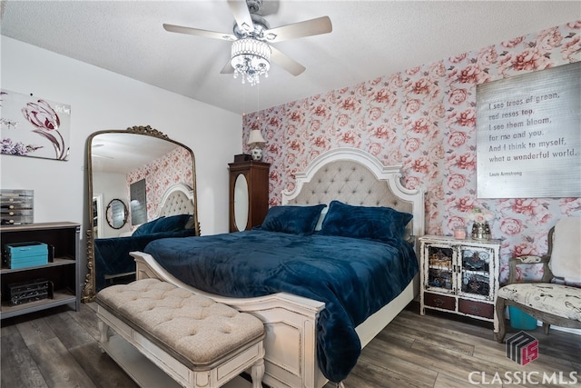 bedroom with dark wood-type flooring, ceiling fan, and a textured ceiling