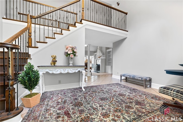 stairs featuring a towering ceiling and tile patterned flooring