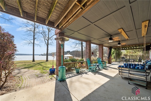 view of patio featuring a water view and ceiling fan