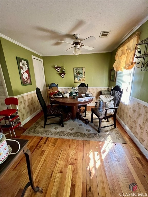 office space featuring crown molding, hardwood / wood-style floors, a textured ceiling, and ceiling fan