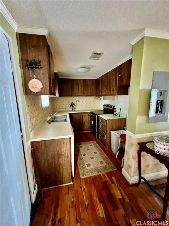 kitchen featuring light countertops, stainless steel electric range oven, visible vents, and a sink