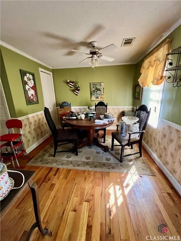 384 Arrowhead Trl Unit 4, Eatonton, GA 31024 - dining area featuring a ceiling fan, wallpapered walls, baseboards, visible vents, and wood finished floors