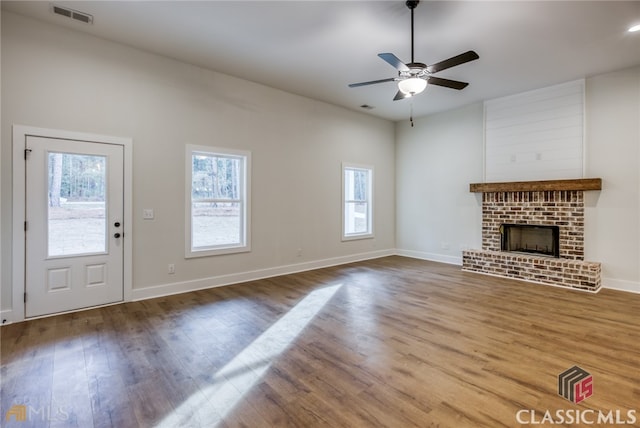 unfurnished living room with ceiling fan, a fireplace, and hardwood / wood-style floors