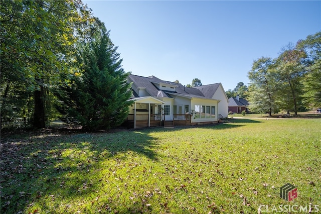 view of yard featuring a sunroom and a deck