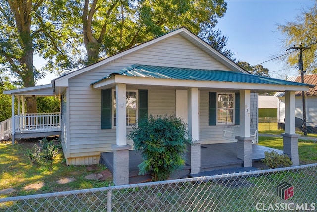 bungalow-style home featuring covered porch and a front lawn