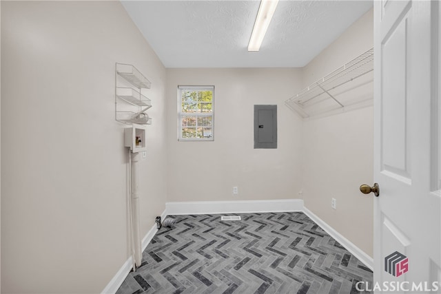 washroom featuring hookup for a washing machine, a textured ceiling, and electric panel