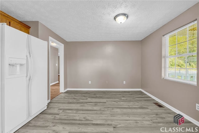 interior space with a textured ceiling and light hardwood / wood-style flooring