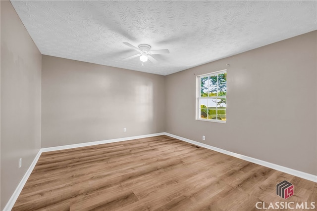 empty room featuring a textured ceiling, hardwood / wood-style flooring, and ceiling fan