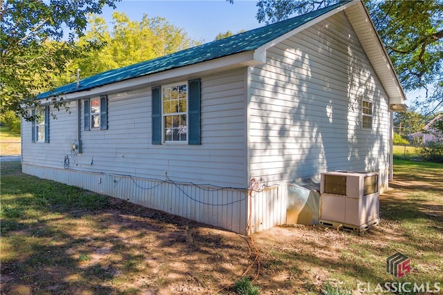 view of side of property featuring a lawn and central AC unit