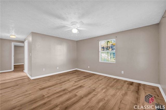 unfurnished room featuring a textured ceiling, light wood-type flooring, and ceiling fan