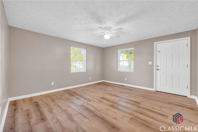 unfurnished room featuring light hardwood / wood-style flooring, a textured ceiling, and ceiling fan