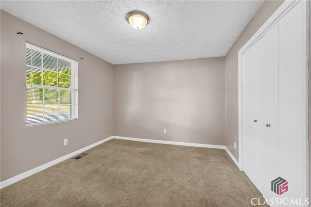 unfurnished bedroom featuring a closet, carpet floors, and a textured ceiling