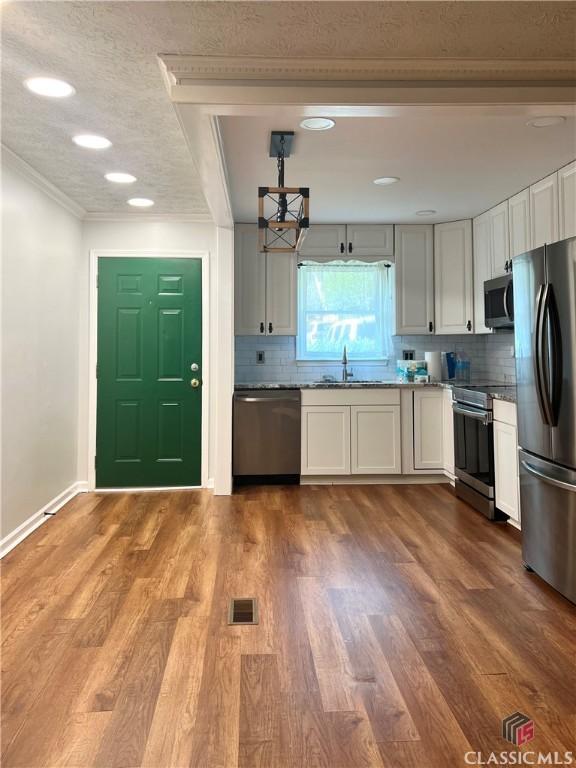 unfurnished dining area featuring wood-type flooring and a textured ceiling