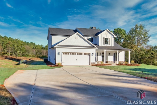 view of front of house featuring a front lawn, covered porch, and a garage