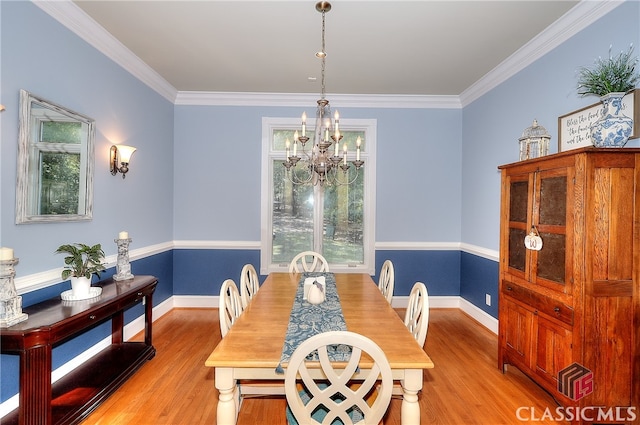 dining space featuring crown molding, light hardwood / wood-style flooring, and a chandelier