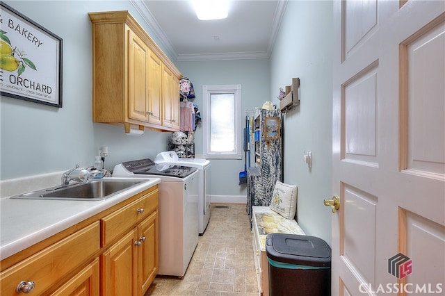 laundry area with washing machine and dryer, crown molding, cabinets, and sink