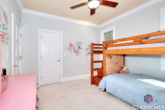 carpeted bedroom with ornamental molding and ceiling fan