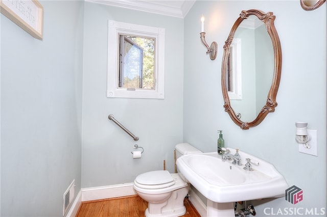 bathroom with toilet, crown molding, sink, and wood-type flooring