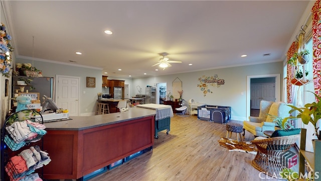 interior space featuring crown molding, light hardwood / wood-style flooring, and ceiling fan