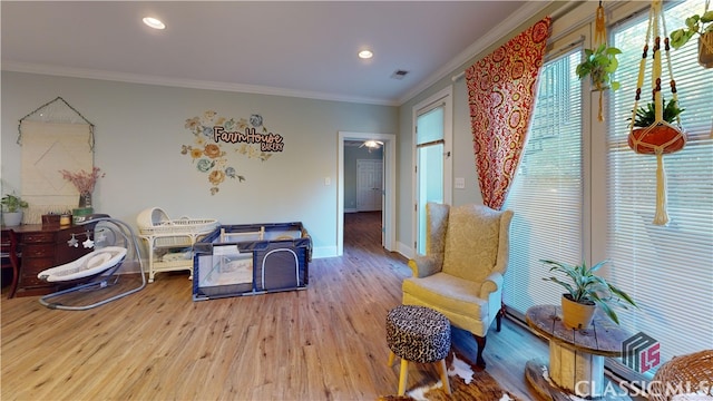 sitting room featuring ornamental molding and wood-type flooring