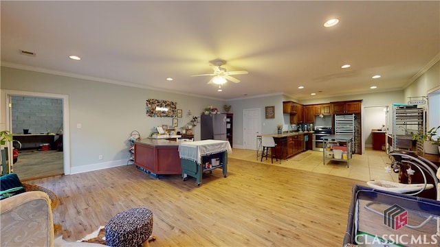 interior space with stainless steel fridge, light hardwood / wood-style flooring, ornamental molding, and sink