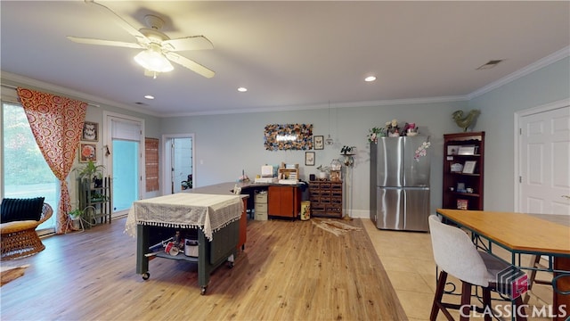 interior space featuring crown molding, light wood-type flooring, and ceiling fan