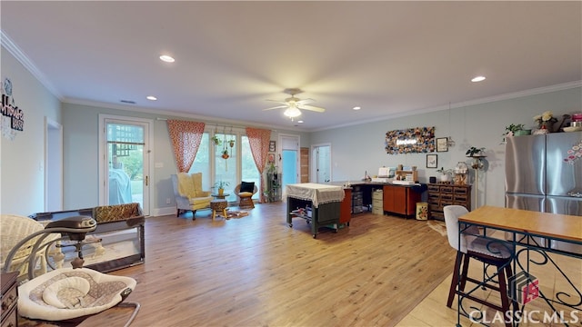 living room with ceiling fan, ornamental molding, and light hardwood / wood-style flooring