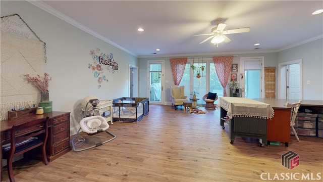 living room featuring crown molding, light hardwood / wood-style flooring, and ceiling fan