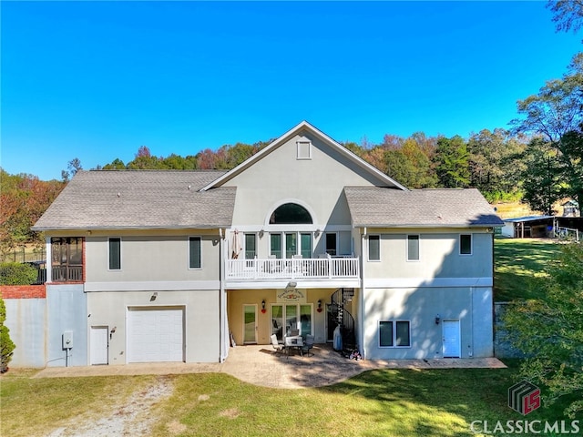 rear view of property with a yard, a patio, a balcony, and a garage