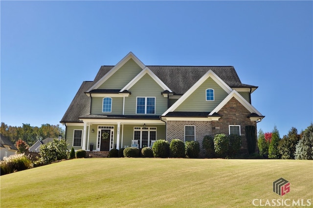 craftsman-style house featuring covered porch and a front lawn