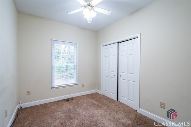 unfurnished bedroom with a closet, carpet flooring, and ceiling fan