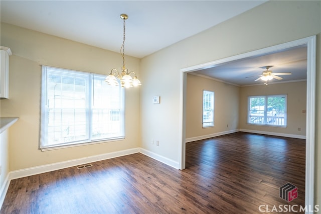 unfurnished dining area featuring dark hardwood / wood-style flooring, crown molding, and ceiling fan with notable chandelier