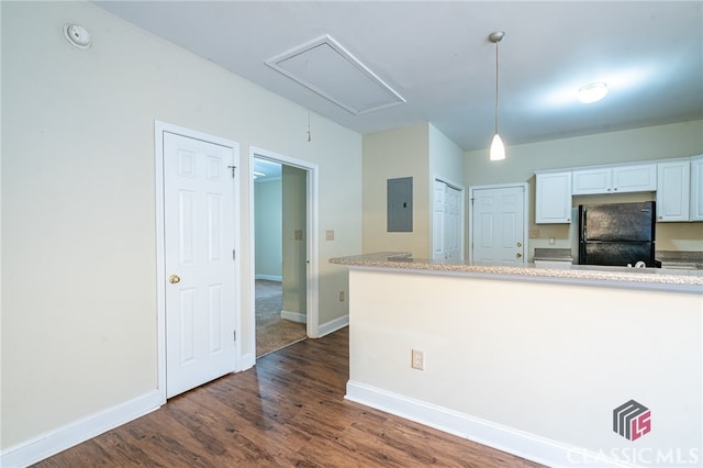 kitchen featuring electric panel, black fridge, dark hardwood / wood-style flooring, white cabinets, and hanging light fixtures