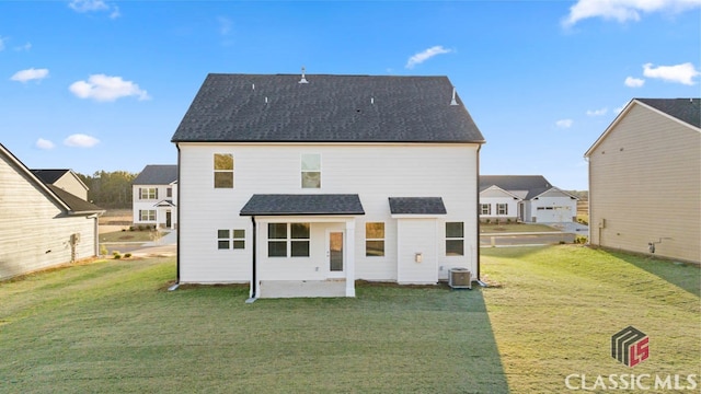 back of property with central AC and a lawn