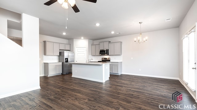 kitchen featuring appliances with stainless steel finishes, a kitchen island with sink, a healthy amount of sunlight, and gray cabinets