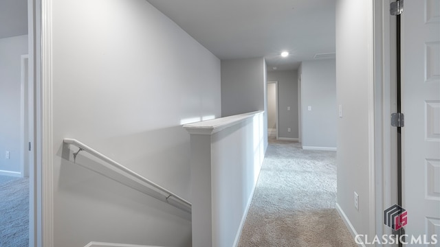 hallway featuring light colored carpet