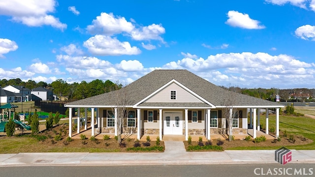 farmhouse inspired home featuring covered porch and a playground